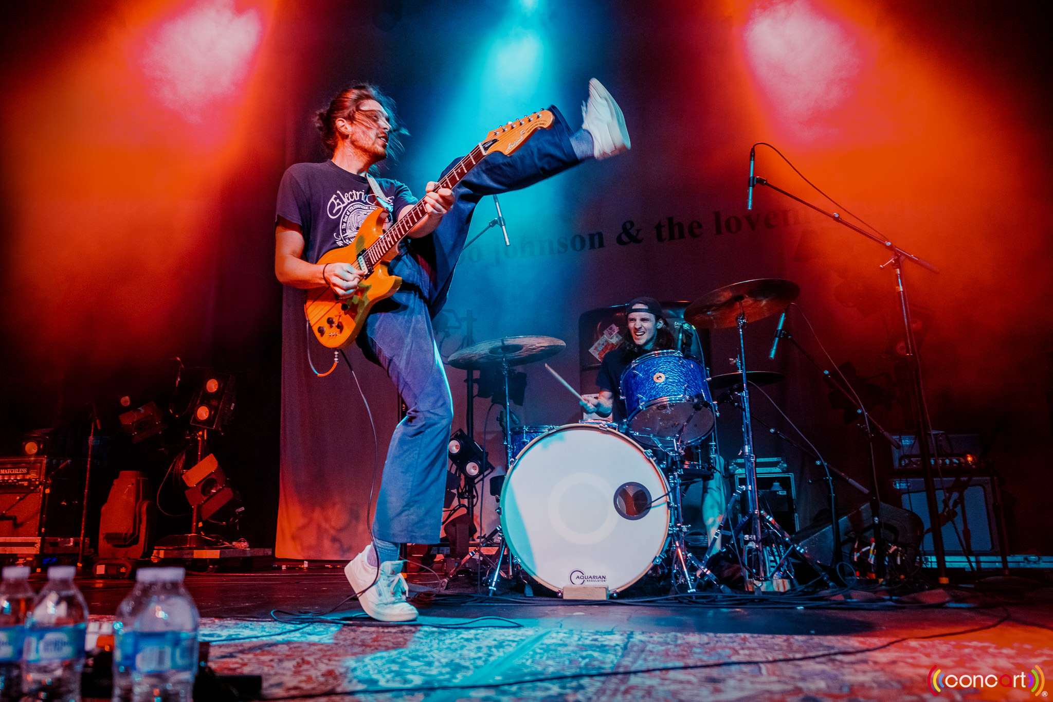 Erik Paulson of the band Remo Drive kicking his leg up while playing guitar.