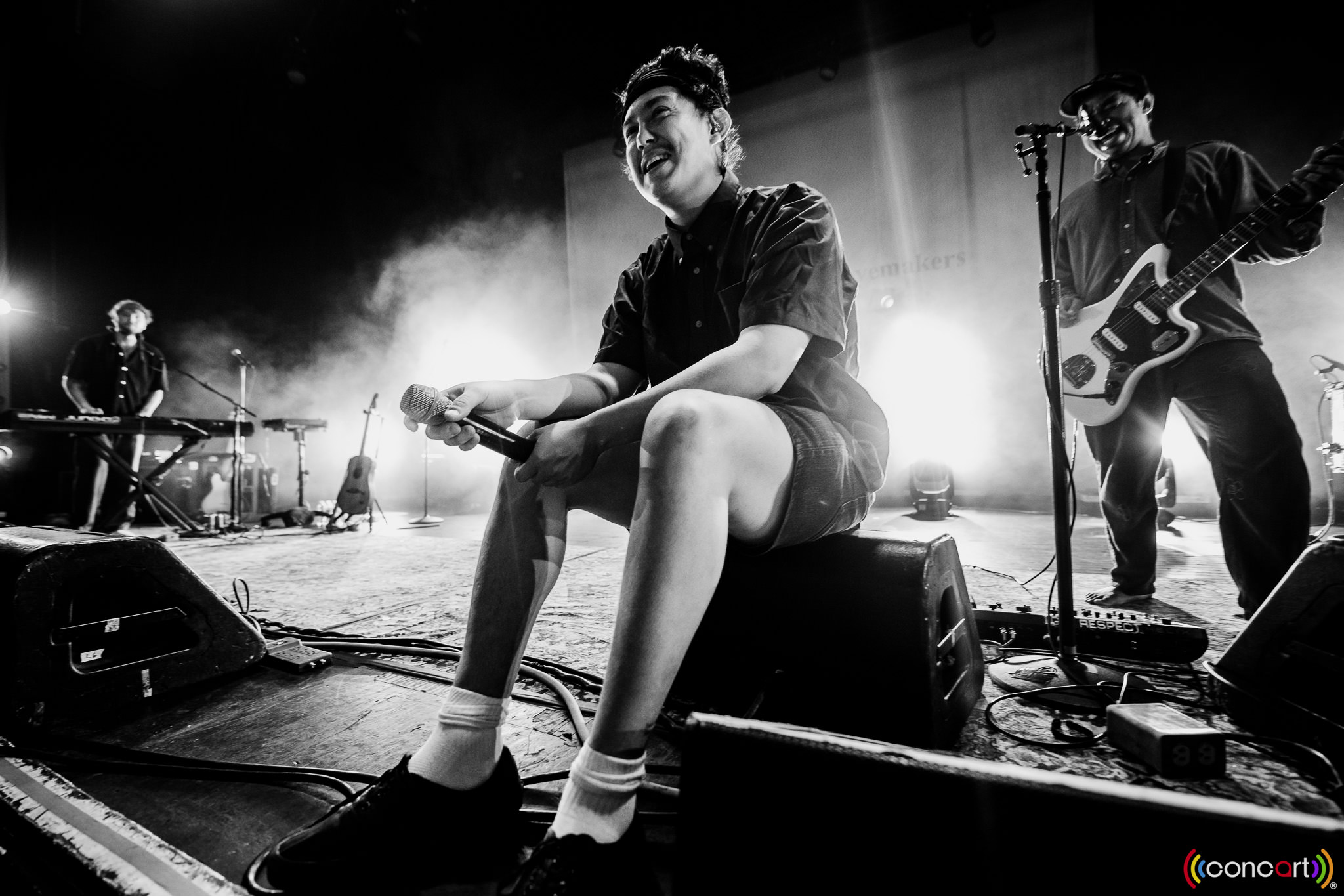 Hobo Johnson sitting on stage conversing with the crowd.